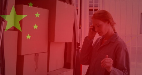 Image of chinese flag waving over woman using smartphone next to cardboard boxes