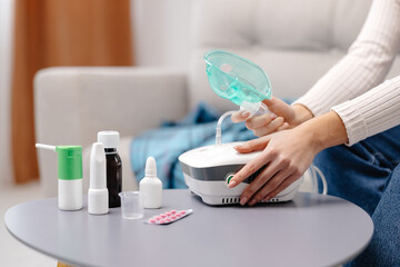 Close-up photo of sick woman with an inhaler. Unhealthy girl presses the button on the inhaler to...