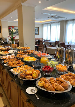 Buffet de caf&eacute; da manh&atilde; variado em hotel com p&atilde;es, frutas, sucos e bolos.