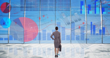 Statistical data processing over businesswoman against blue sky in background