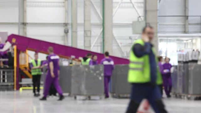 Efficient delivery workers sorting parcels in a large and modern logistics center. Blurred motion. 4K video.