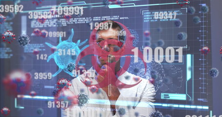 Image of screen with biohazard sign, covid 19 cell and medical data processing over male doctor