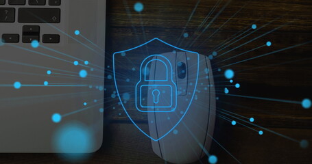 Image of online security padlock with blue spots over laptop and mouse in desk