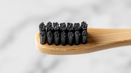 Charcoal toothpaste on bamboo toothbrush isolated on white background. Swatch of black charcoal whitening toothpaste on brush for design.