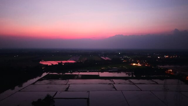 Drone flying over flooded crop fields at dusk in Nakhon Sawan Province