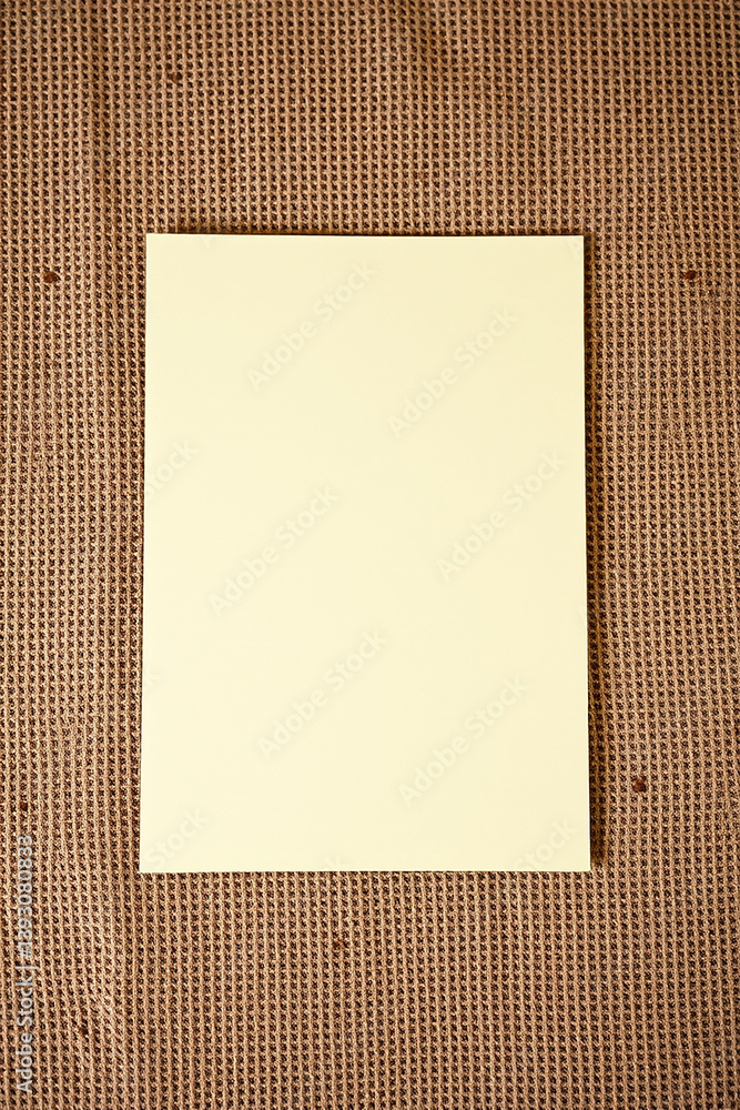 Poster yellow paper on brown material. blank yellow paper. simple paper on burlap. brown burlap background 