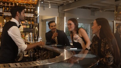 Smart bartender with VIP customer at luxurious bar greeting new beautiful guest at counter in engaging lively conversation at back view in lighting atmosphere at lighting warm nightclub. Vinosity.