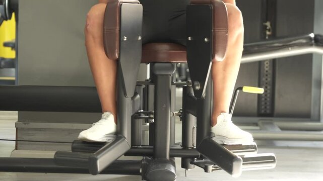 Confident woman uses seated adduction machine in gym, focusing on inner thigh strength, muscle control, and body toning. 