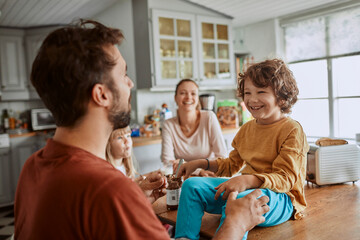 Young family having breakfast in the morning in the kitchen