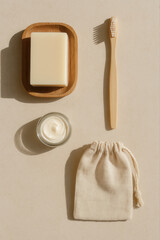 Kit d’hygiène zéro déchet minimaliste avec savon solide, brosse à dents en bambou, crème et pochette en tissu sur fond beige lumineux