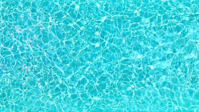 Blue water in the swimming pool with light reflections.