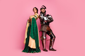 Medieval couple in costumes posing against pink, dressed as princess and knight © deagreez