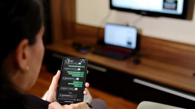 A woman holds a smartphone with the WhatsApp app on the screen while using the mobile voice messaging app at home. Chatting on WhatsApp. March 15, 2025 Almaty Kazakhstan