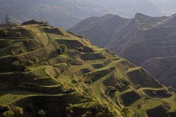 Green terraces on a mountain slope near the village of Chokh in Daestan. View of the terraces created to level the mountainous terrain for crop production. A visual example of terrace farming