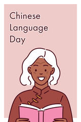 Senior dark-skinned woman with white hair smiling and holding book in red traditional outfit for Chinese Language Day celebration, promoting cultural diversity and literacy