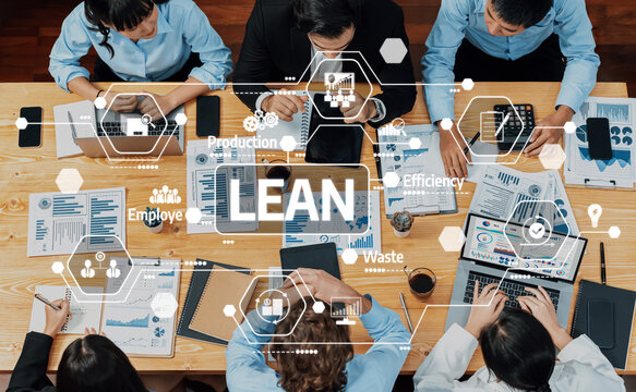 A diverse team collaborates in a meeting to enhance efficiency and reduce waste through lean management strategies, utilizing digital tools and data analysis. Amity