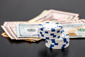 Stacks of poker chips with money on black background