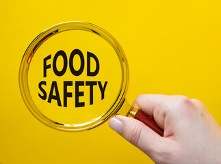 Food Safety symbol. Magnifying glass with words Food Safety. Beautiful yellow background....