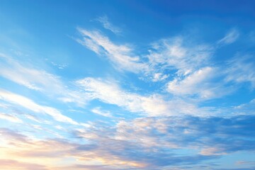 Obraz premium bright blue sky with soft clouds illuminated by golden hour light creating calm and inviting scene