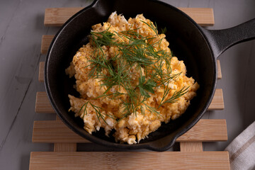 photo Gourmet scrambled eggs crafted with organic ingredients in a luxurious cast iron skillet...