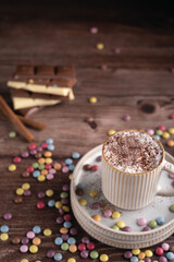 photo Indulge in a Cozy Experience with Frothy Hot Chocolate Topped with Cocoa and Full of Sweet Candy-Coated Chocolates, Ideal for a Comforting Dessert on Any Relaxing Day