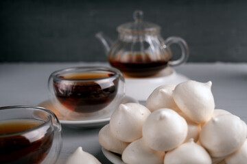 photo Delight in the Harmony of a Tea Experience with Glass Teapot and Cup Accompanied by Freshly Baked Meringue Cookies in a Serene Setting for Tasteful Relaxation