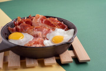 photo Delicious Cast Iron Skillet Breakfast with Crispy Bacon and Sunny Side Up Eggs for a Perfect...