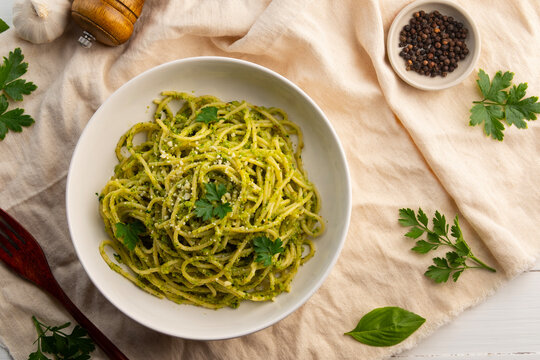 Vegetarian vegan green pasta, Spaghetti pasta with broccoli pesto sauce and vegan cheese in white plate.Healthy food.Top view. - Powered by Adobe