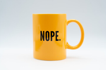 Bright yellow ceramic mug with bold black text reading “NOPE.” against a white background.