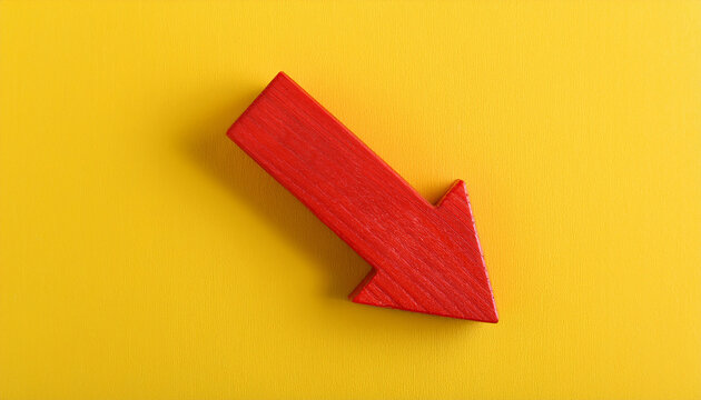 Red wooden arrow pointing downwards on yellow background. Business, market decline or economic