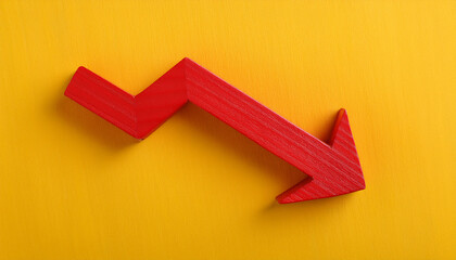 Red wooden arrow pointing downwards on yellow background. Business, market decline or economic