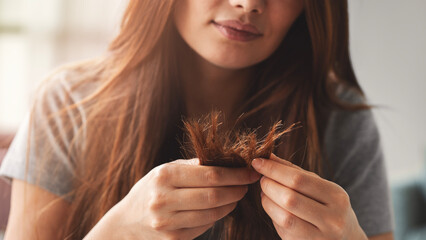 Woman looks at her damaged hair