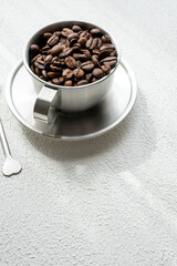 coffee beans in metal cup on white background