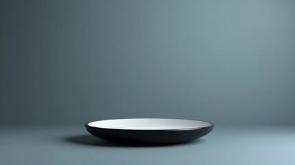 A minimalist studio shot featuring a black and white plate against a muted gray background space