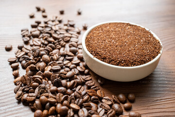 coffee beans, a cup of espresso and ground coffee on brown background