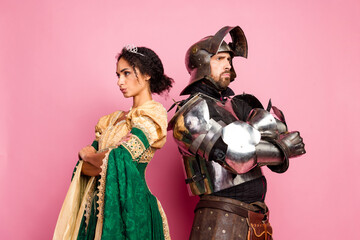 Couple Dressed as Medieval Characters Knight and Noblewoman Against Pink Background