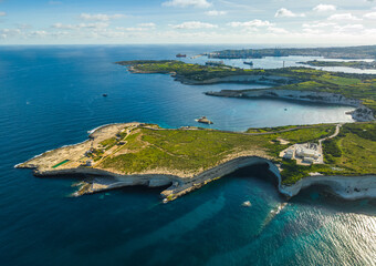 Drone aerial view of south part of Malta island. Green hills, fields, rocks and cliffs, sea
