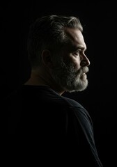 Mature Man in Low-Key Lighting Looking Thoughtful