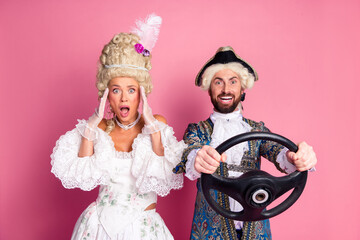 Elegant couple in theatrical costumes posing with vibrant expressions on pink background