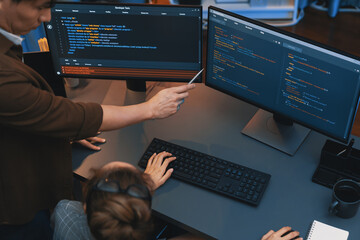 Top view of IT developers discussing with point to intelligent website development coder system...