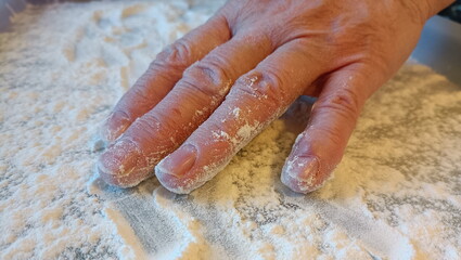 Adult's hand on a tray with flour while cooking