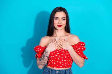 Young woman in trendy red outfit with hand gesture on vibrant blue background