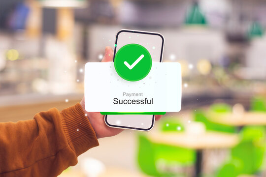 Man holding a smartphone with a successful payment at a coffee shop. Online payment concept.