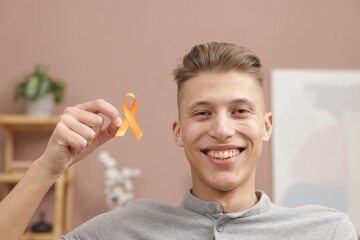 Multiple Sclerosis awareness. Man with orange ribbon indoors