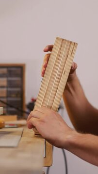 Leathersmith installs tool on workbench surface to process leather in workshop closeup. Master crafts original accessories from natural leather material