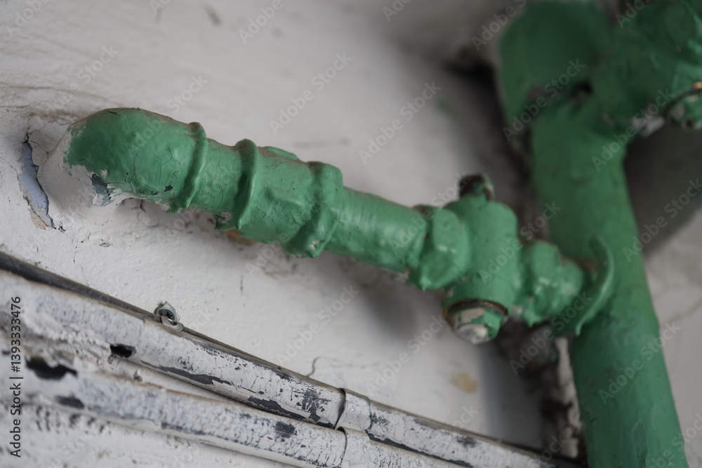 Poster A detailed view of a green pipe fixed to a wall, suitable for use in architectural or DIY contexts