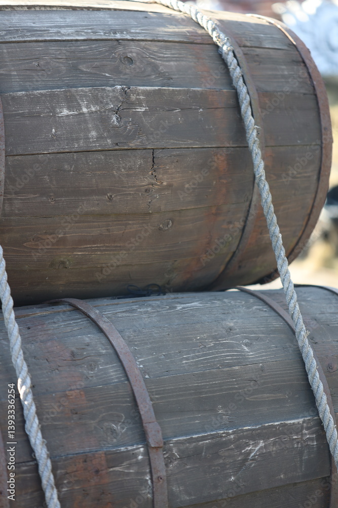Poster a rustic scene with two wooden barrels suspended from a rope, suitable for use in country-themed or 