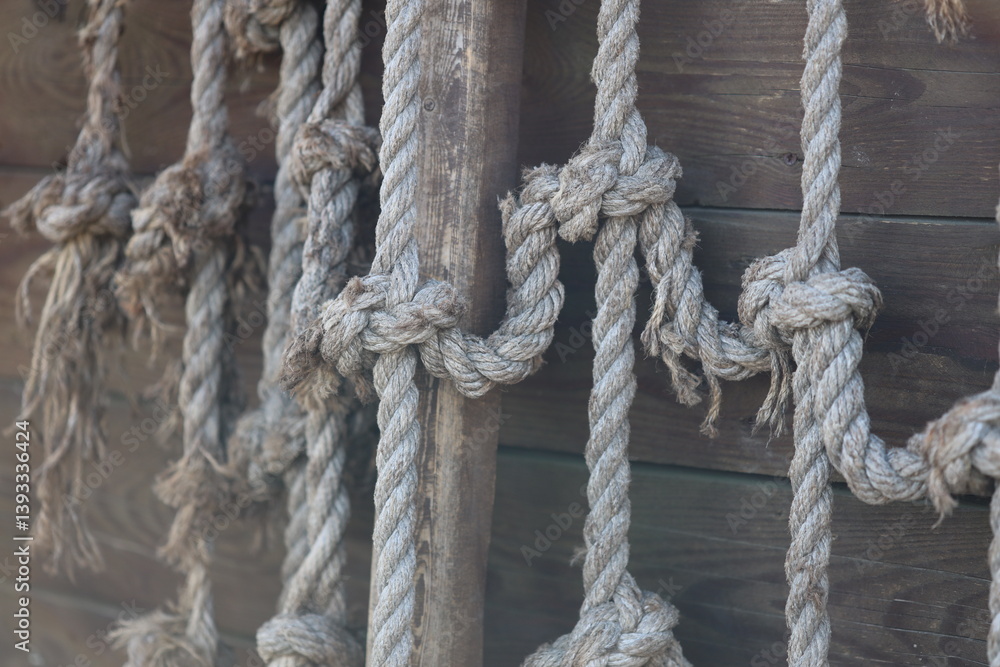 Poster a bunch of rope hanging on the side of a building, potential for climbing or support.