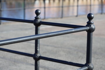 Naklejka premium A close-up shot of a metal fence with a body of water in the background, perfect for use as a decorative element or to add a touch of tranquility to your design.