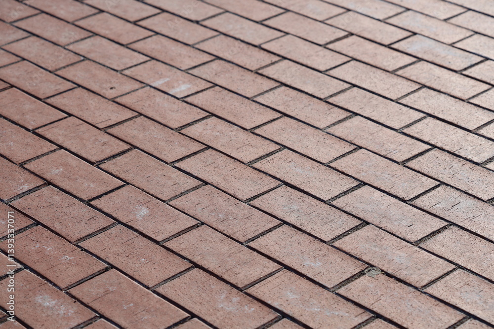 Poster close-up shot of a worn red brick sidewalk with subtle texture and imperfections.